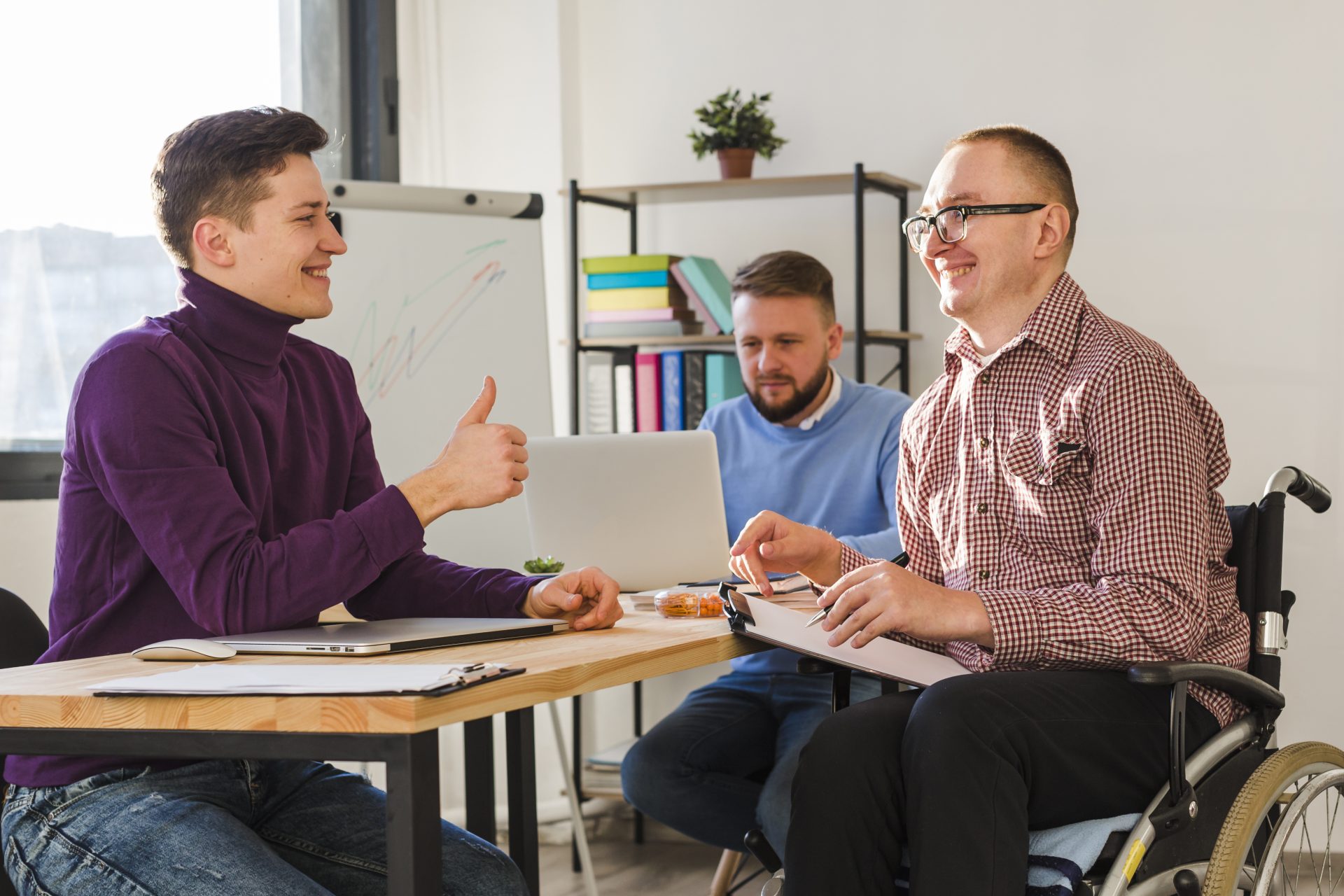 3 professionals working together on a project to help kids with tailored assistance needs