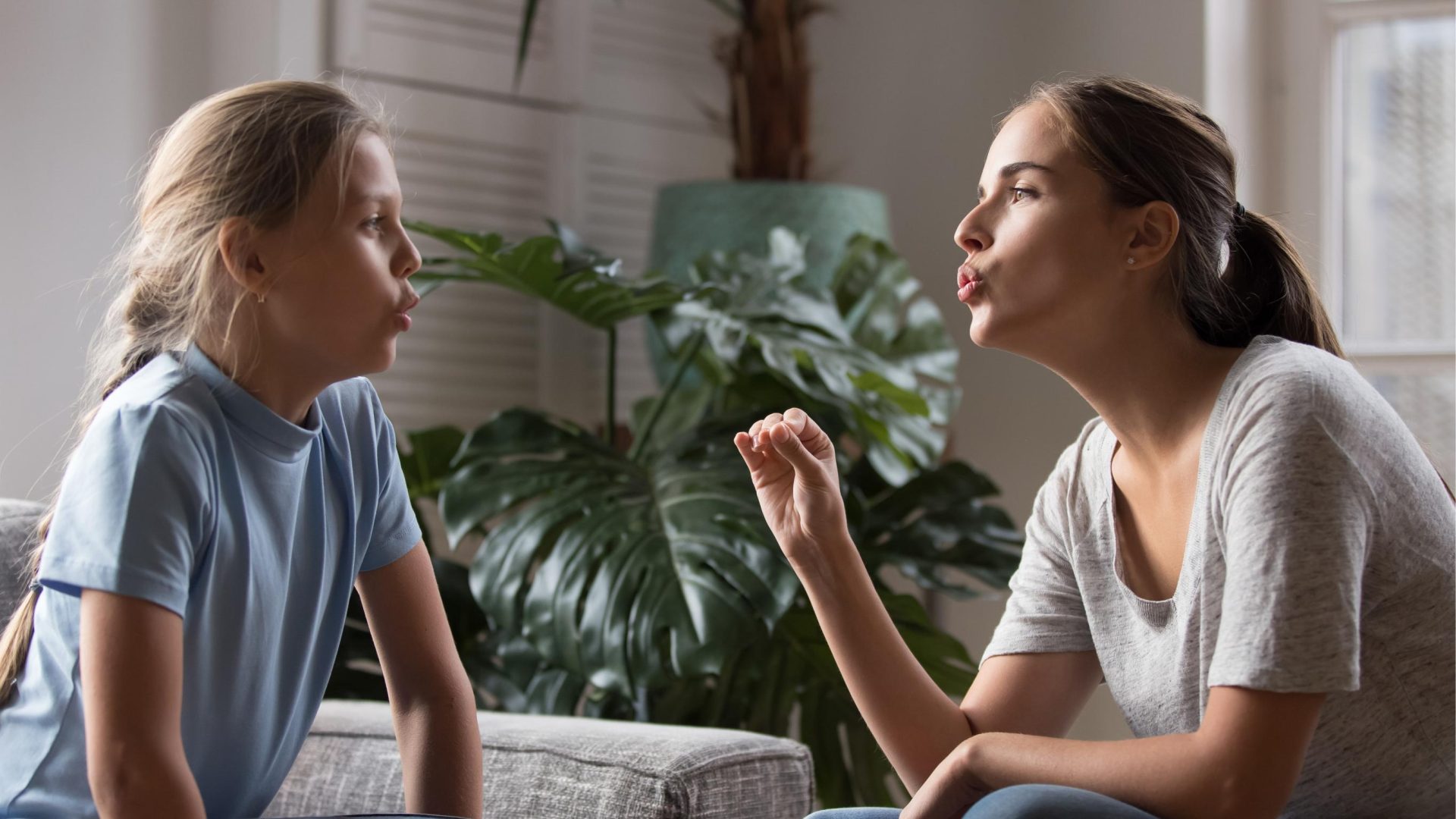 Woman teaching little girl articulate words