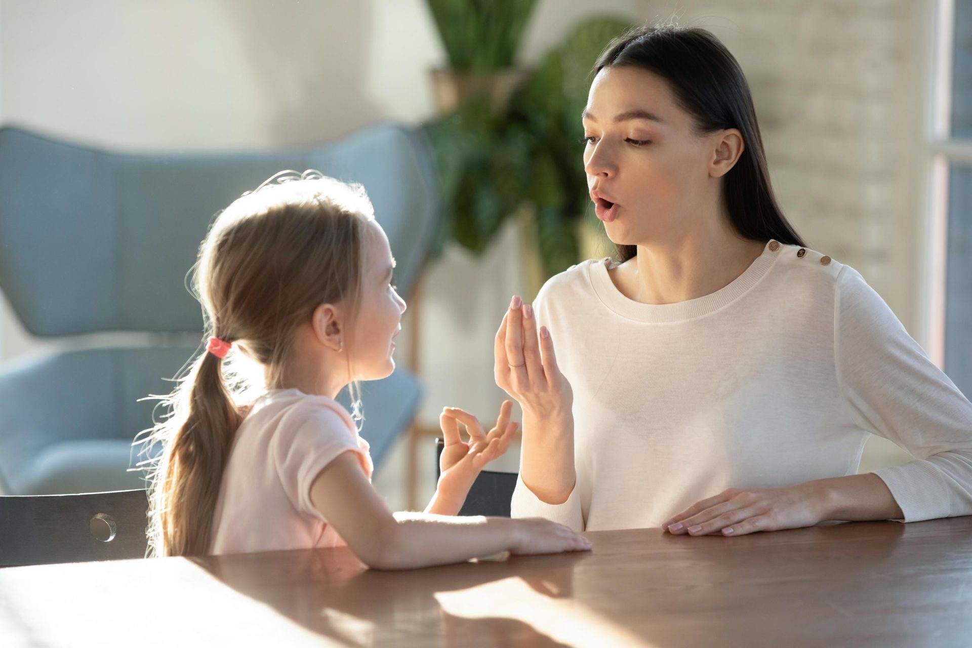 Woman helping and teaching little girl