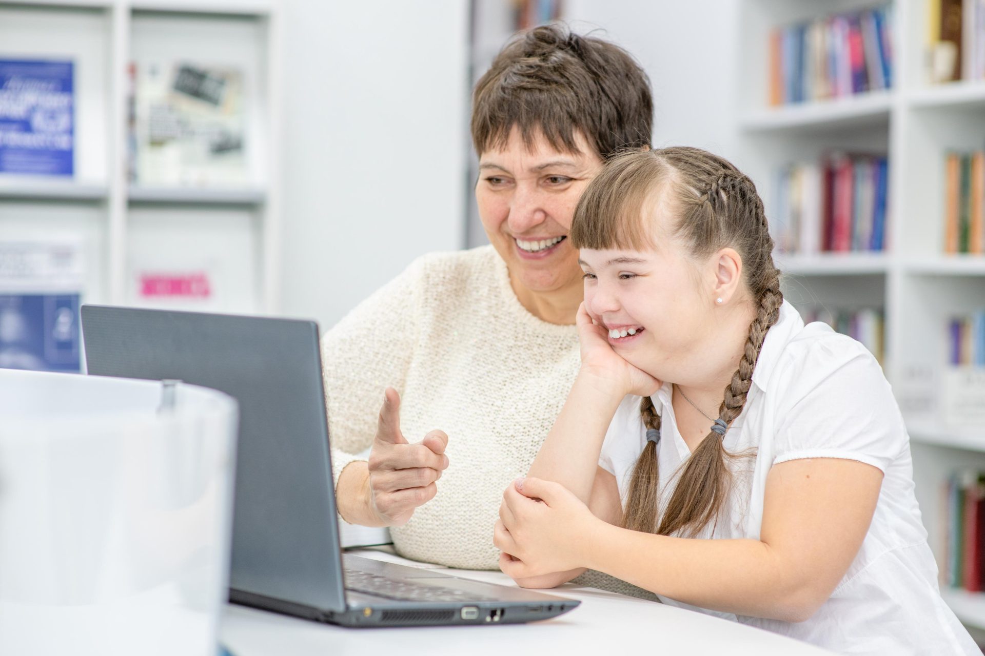 Woman teaching child who needs tailored assistance