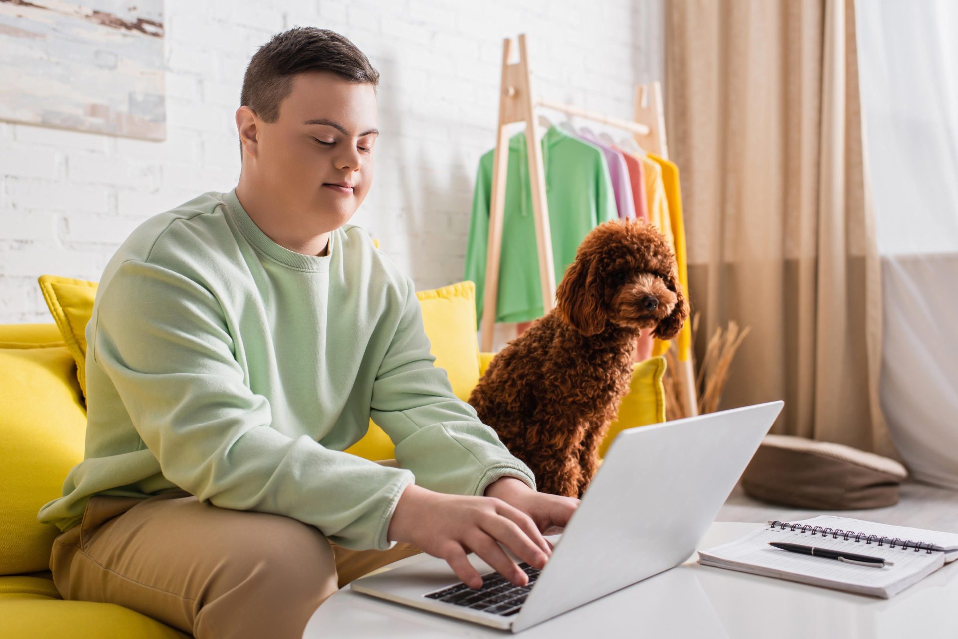 Child with tailored assistance needs studying with their dog next to them