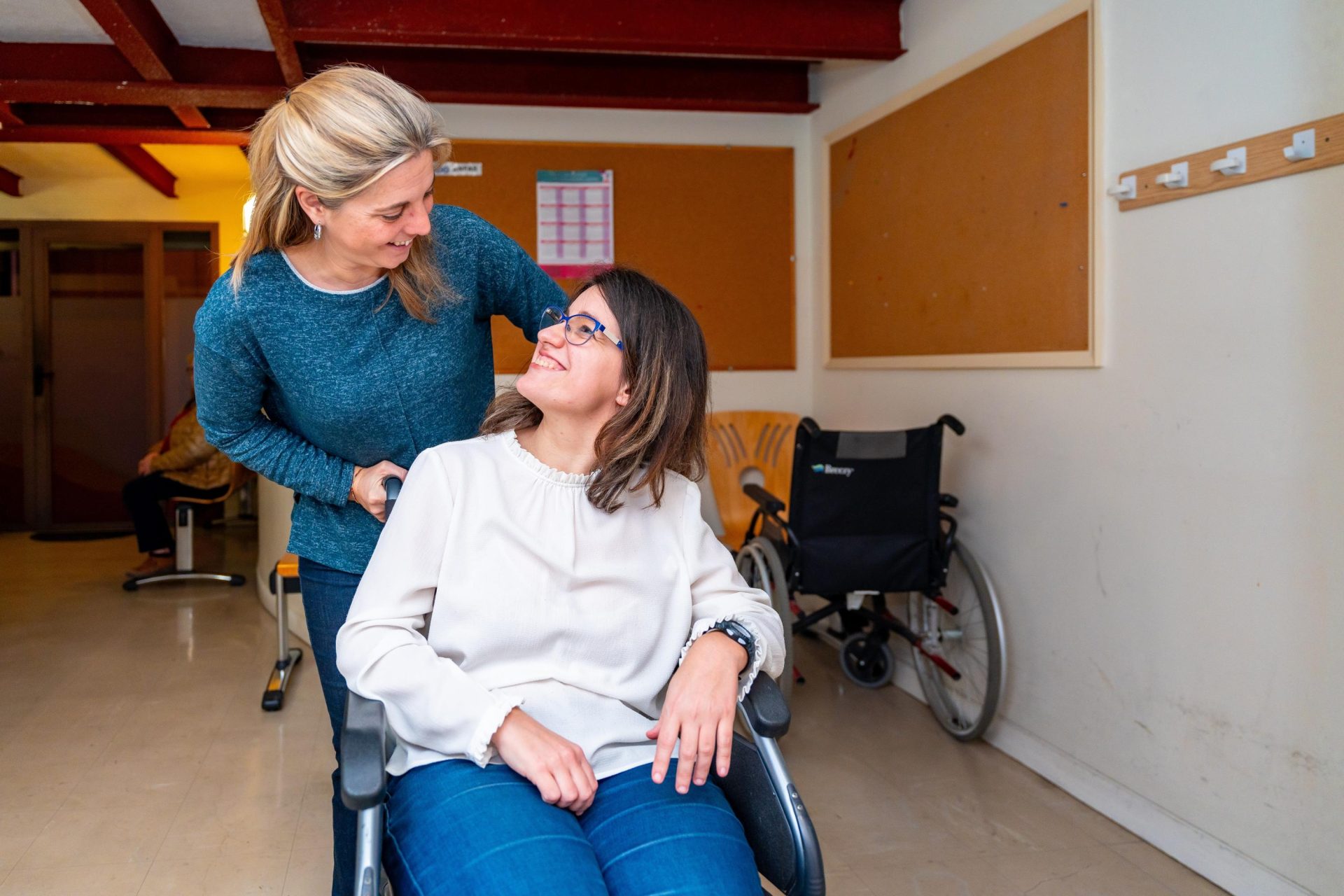 Carer helping girl on wheelchair